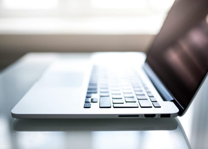 Free Elegant side view of a laptop on a glossy table with natural lighting indoors. Stock Photo